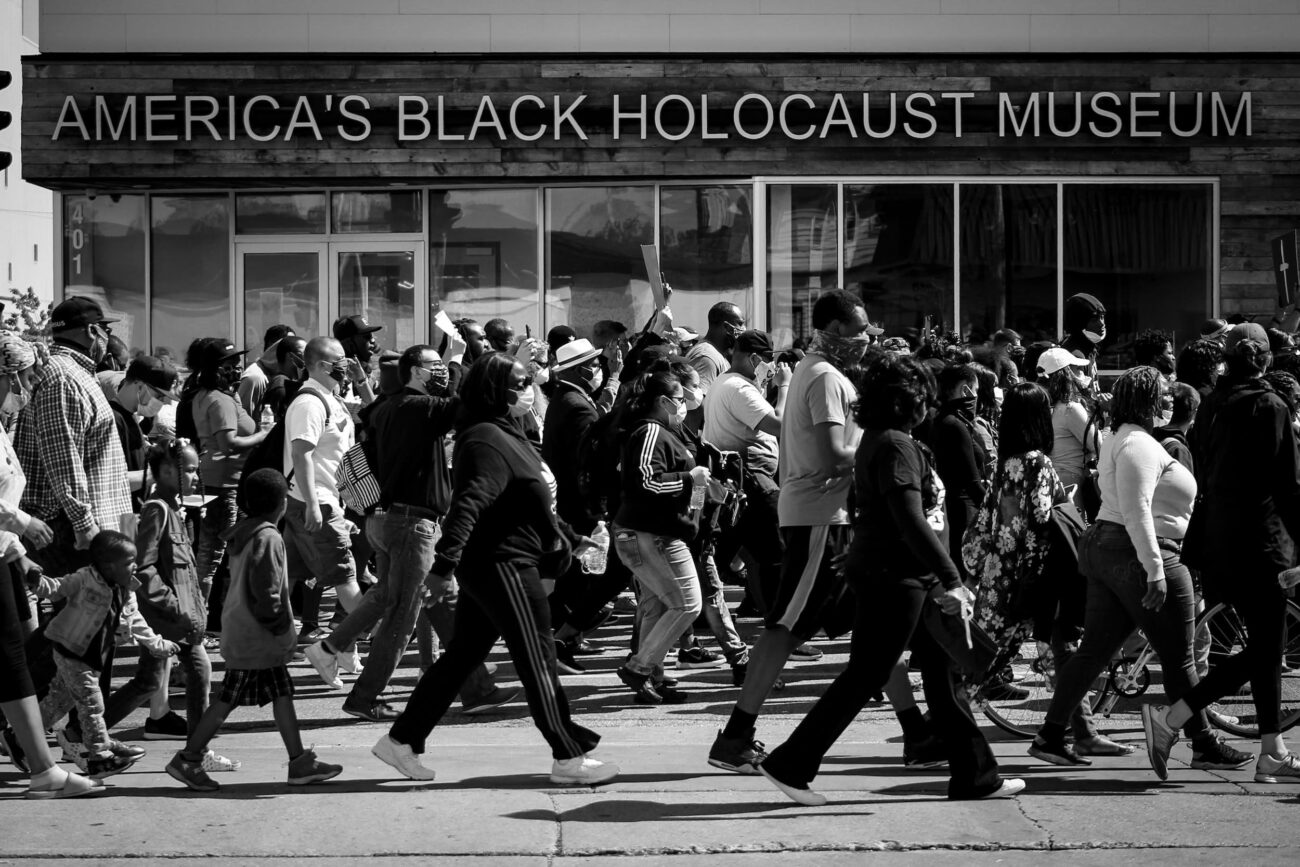 Protestors in the street marching past America's Black Holocaust Museum